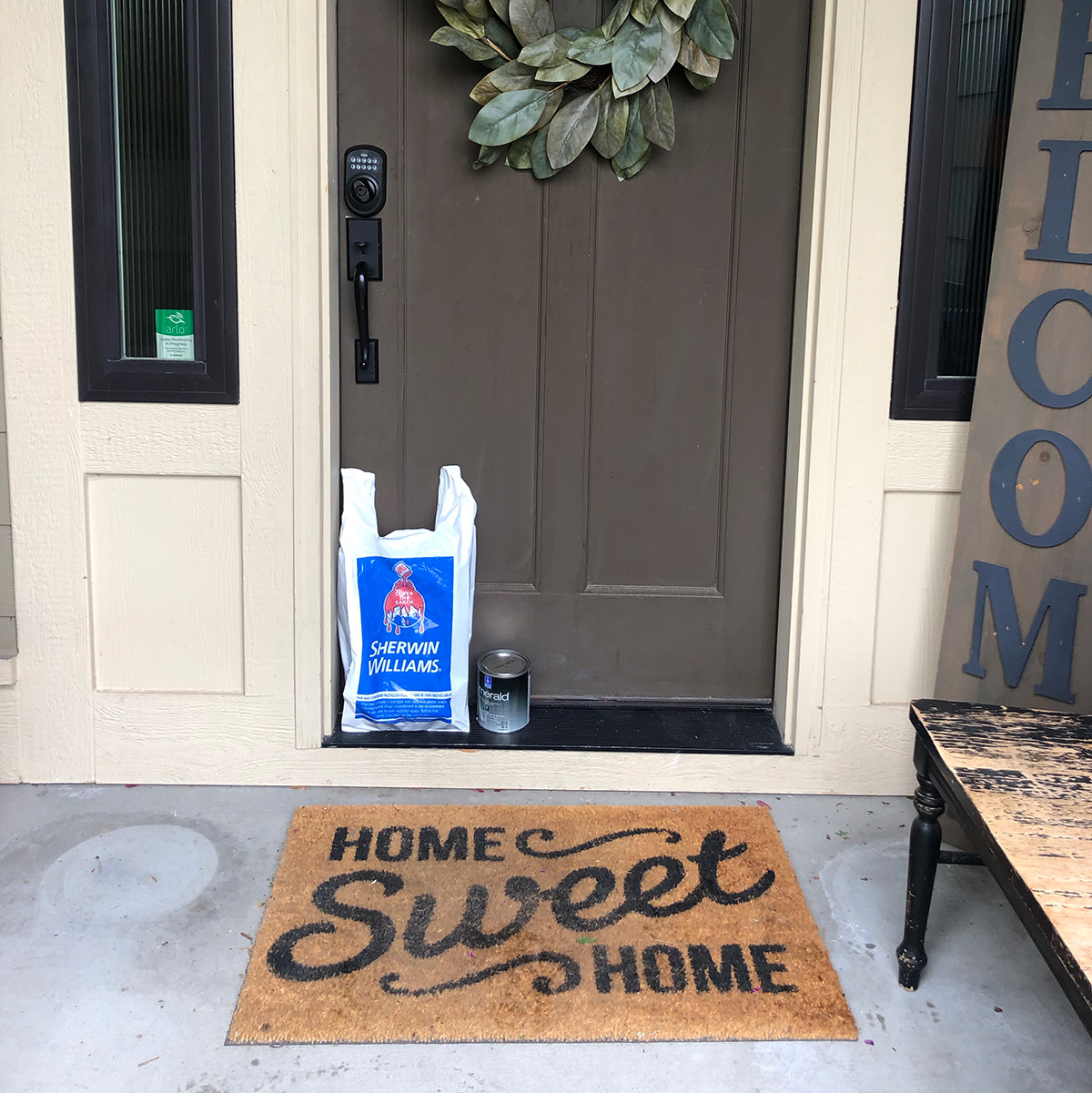 brown front door with a bag from sherwin williams