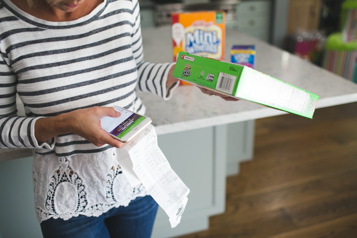 woman holding phone and cereal box