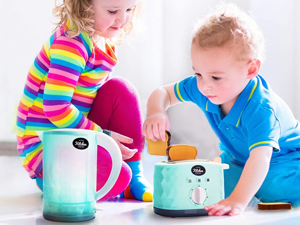 boy and girl playing with toy toasted and kettle