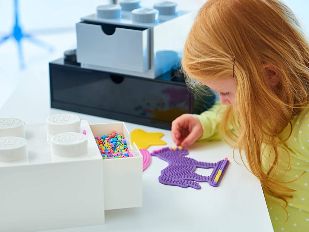 little girl making crafts at table