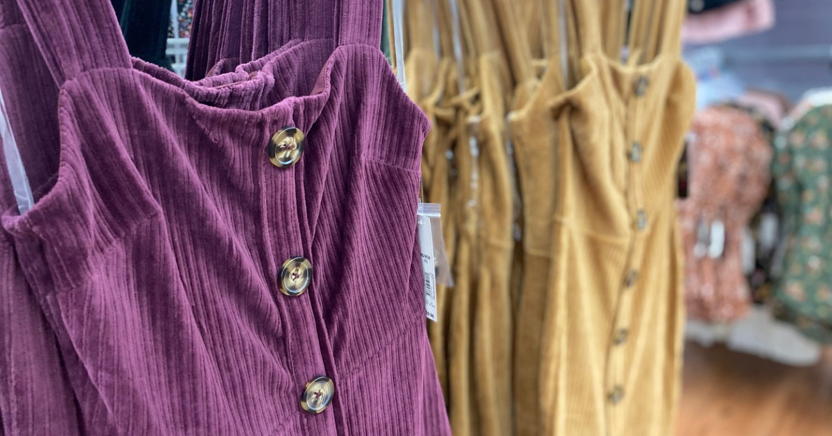 purple and yellow dresses on hangers in store