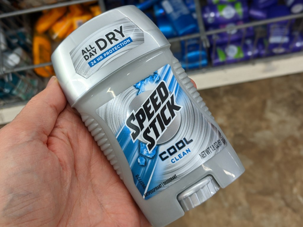 hand holding stick of deodorant by store display