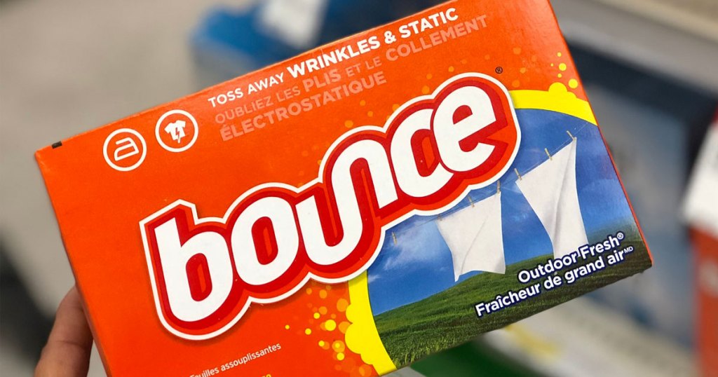 person holding up an orange box of outdoor fresh scented bounce dryer sheets