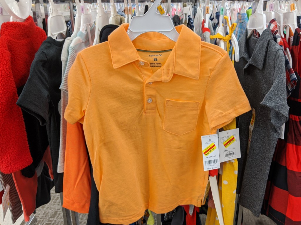 toddler boys orange polo shirt hanging in store