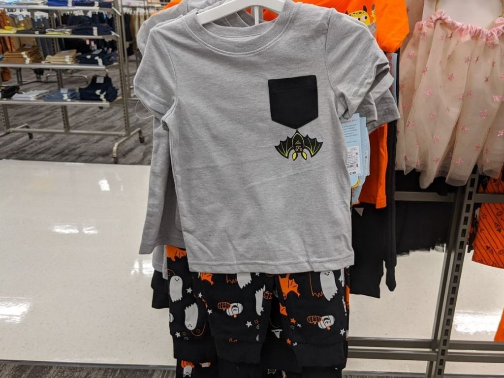 kids short sleeved shirt and pants set on hanger at store featuring Halloween bat graphics