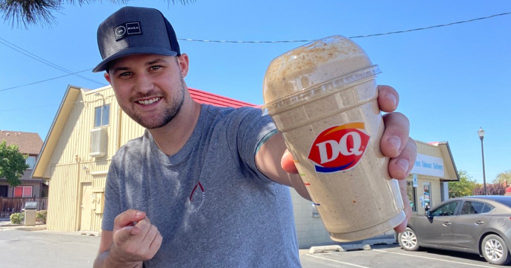 man standing outside pointing at ice cream blizzard