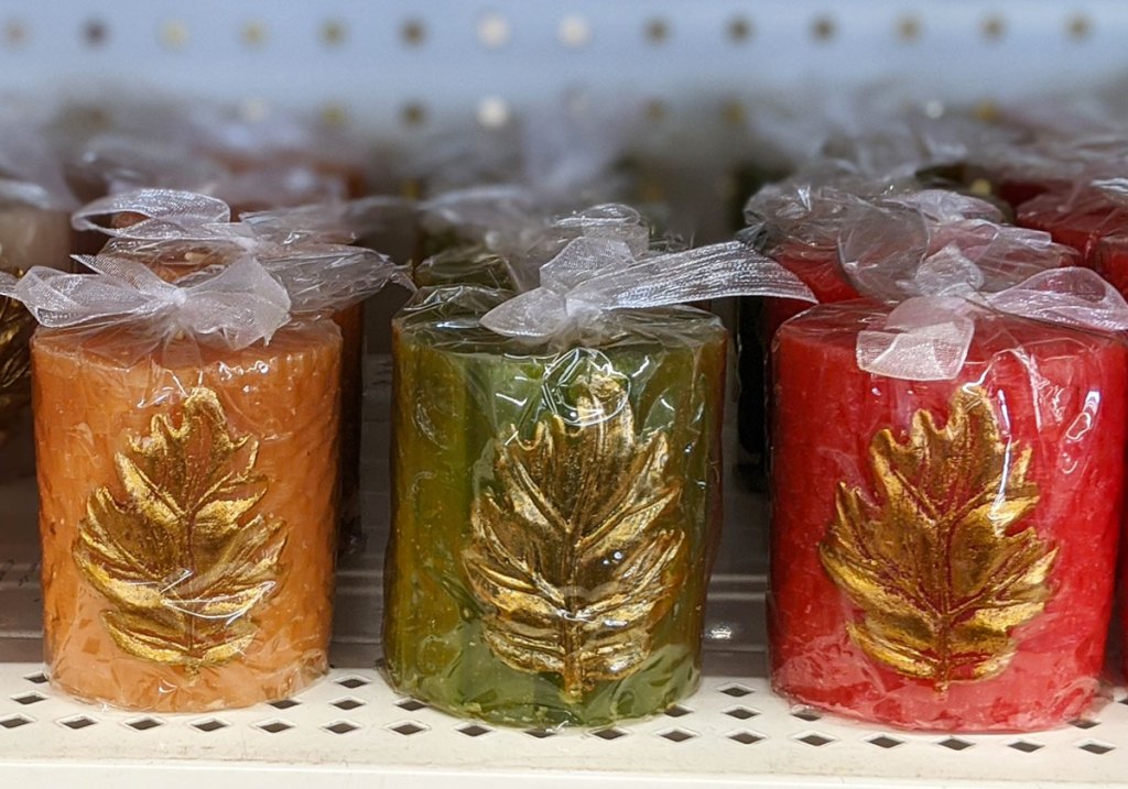 red, green, and yellow votive candles with gold leaves on them