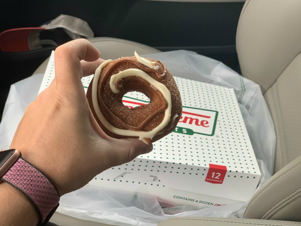 lady holding. a krispy kreme pumpkin spice doughnut