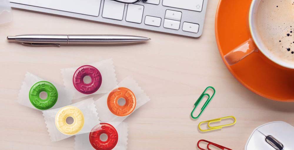 LIfe savers candy on a desk with pen and paper clips