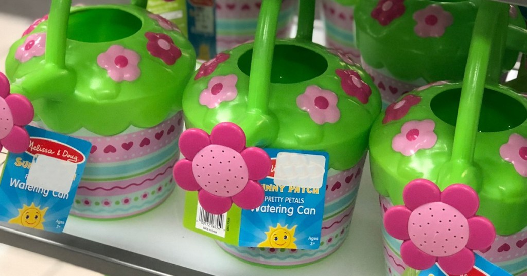 3 Melissa and Doug Pretty Petals Watering Cans sitting on a store shelf