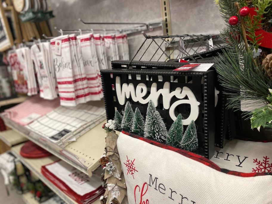 black sign with white merry and christmas trees on shelf at big lots