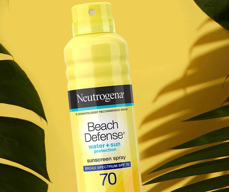 Bottle of sprayable sunscreen on yellow surface