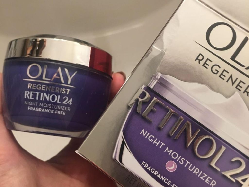 Hand holding jar of Olay Regenerist Retinol24 Night Cream and box