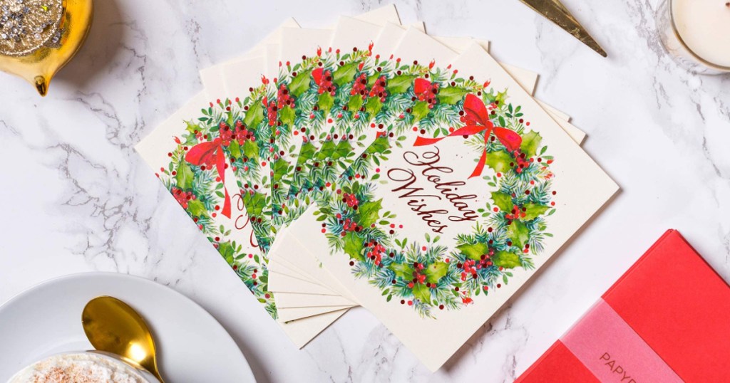 Christmas cards that read holiday wishes surrounded. by a christmas wreath