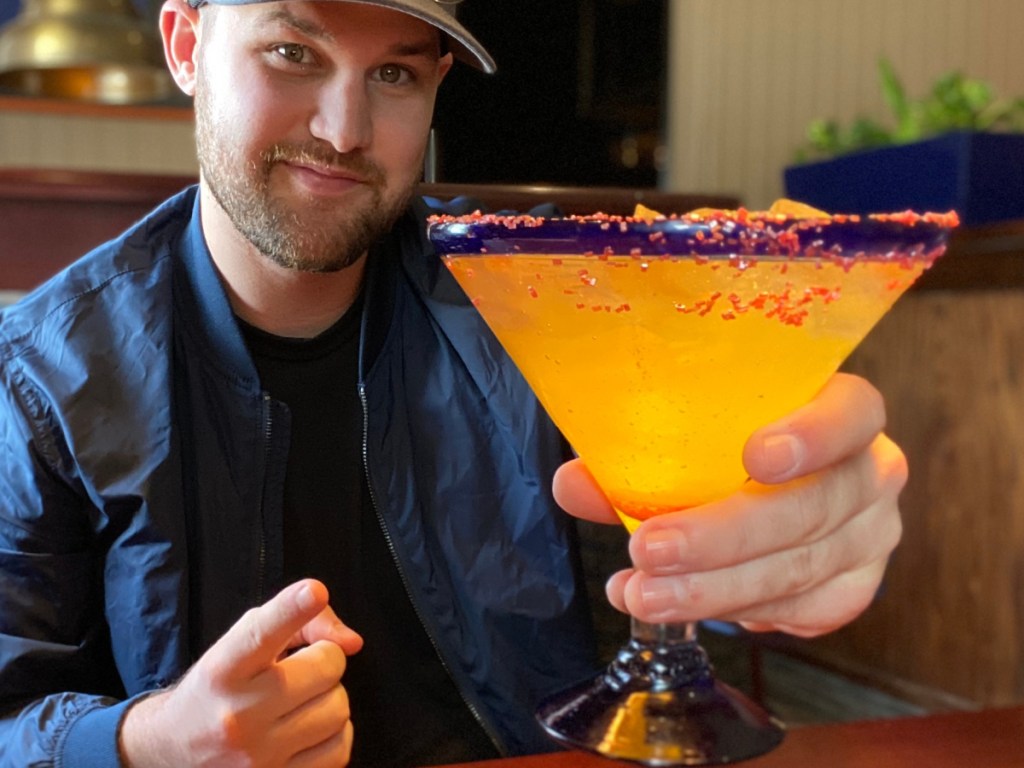 man holding alcoholic drink in restaurant