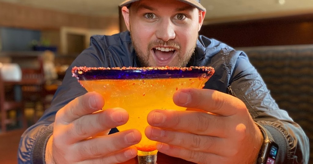 man holding alcoholic drink in restaurant