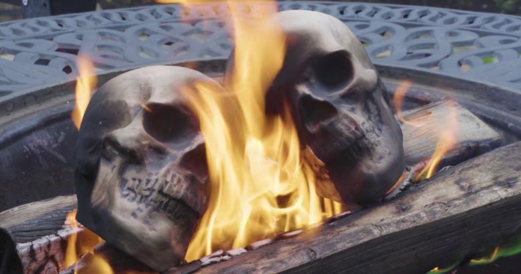 ceramic skulls on fire inside wood fire pit