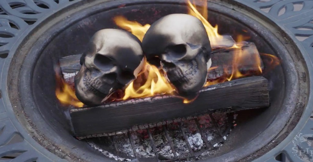 ceramic skulls on fire inside wood fire pit