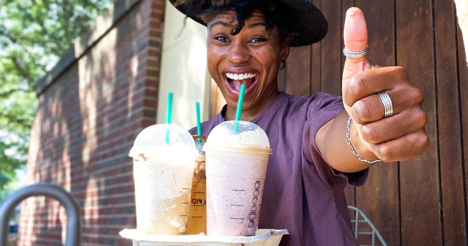 woman holding tray of starbucks drinks