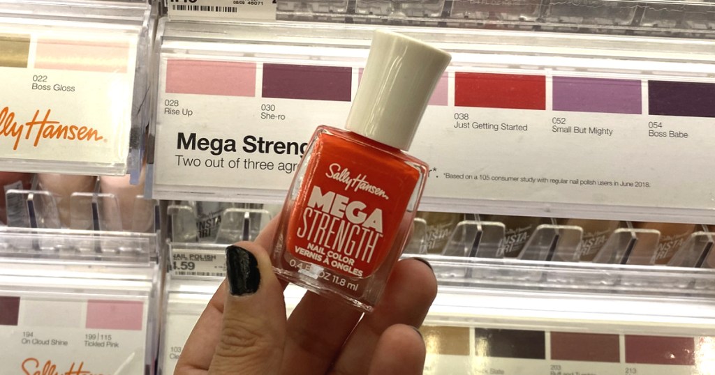 Hand holding Sally Hansen Mega Strength Nail Polish 