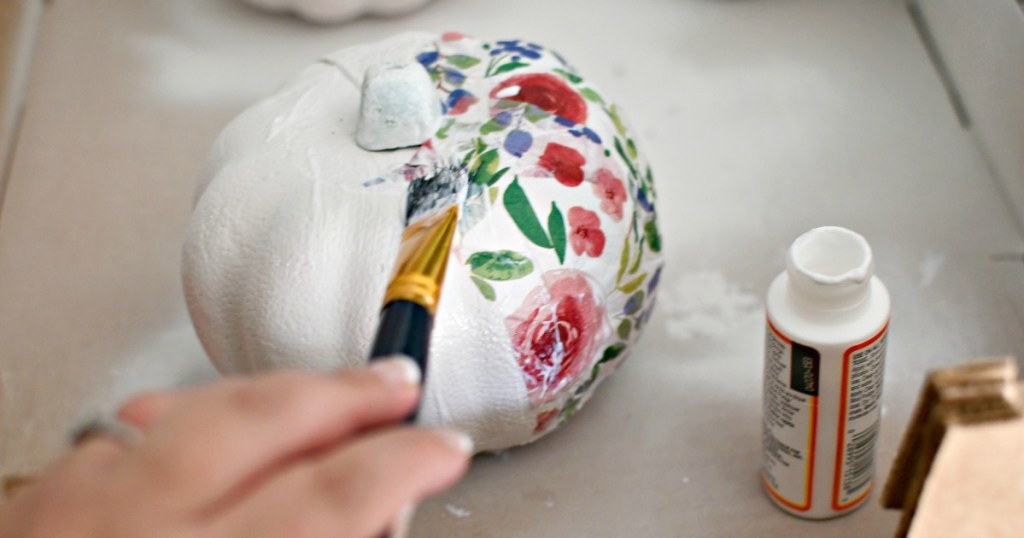 applying tissue paper to craft pumpkins