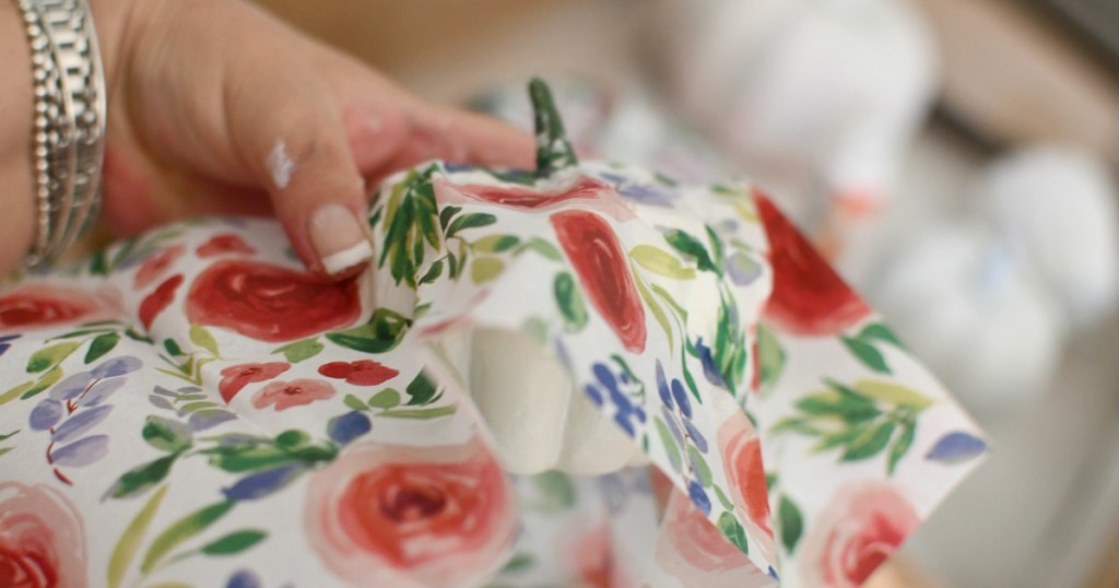 covering small pumpkin with tissue paper and mod podge