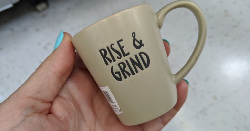 hand holding tiny mug that says "rise & grind"