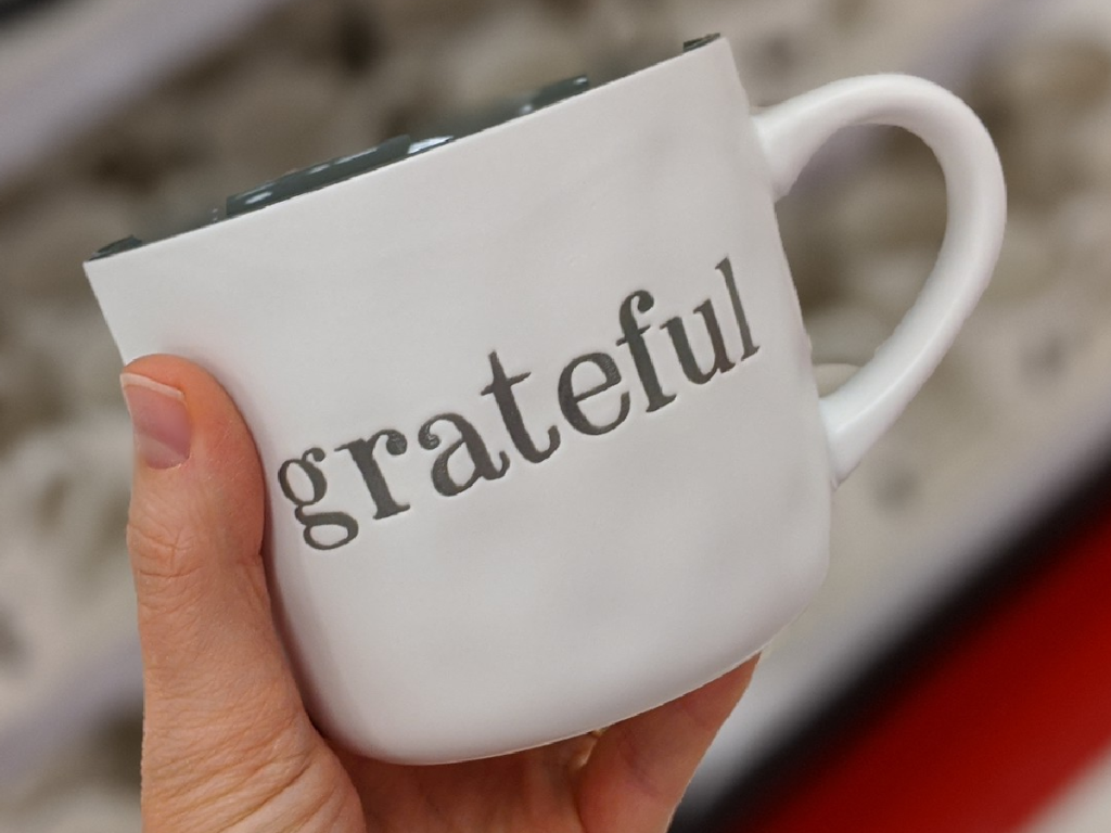 hand holding mug that says "grateful" on it