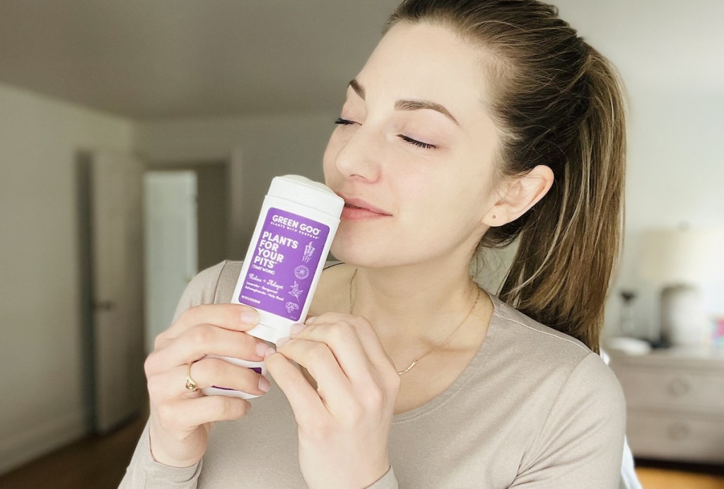 woman holding tube of green goo deodorant