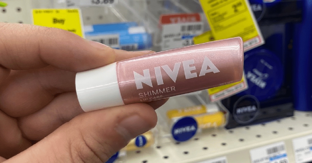 hand holding container of lip care in front of store display