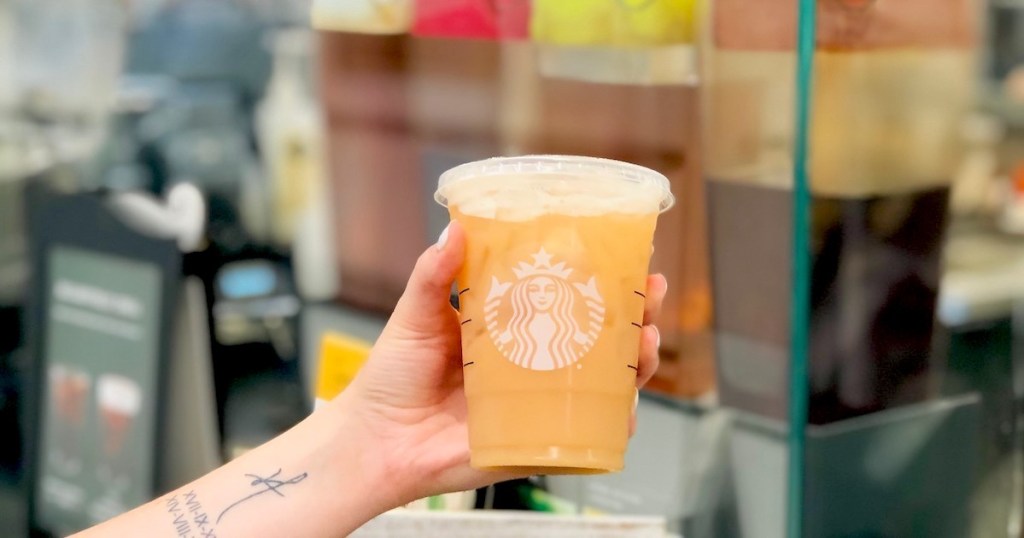 hand holding starbucks peach ring drink