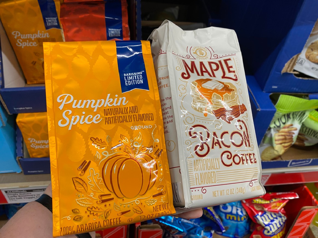 hand holding up 2 bags of fall flavored coffee in store