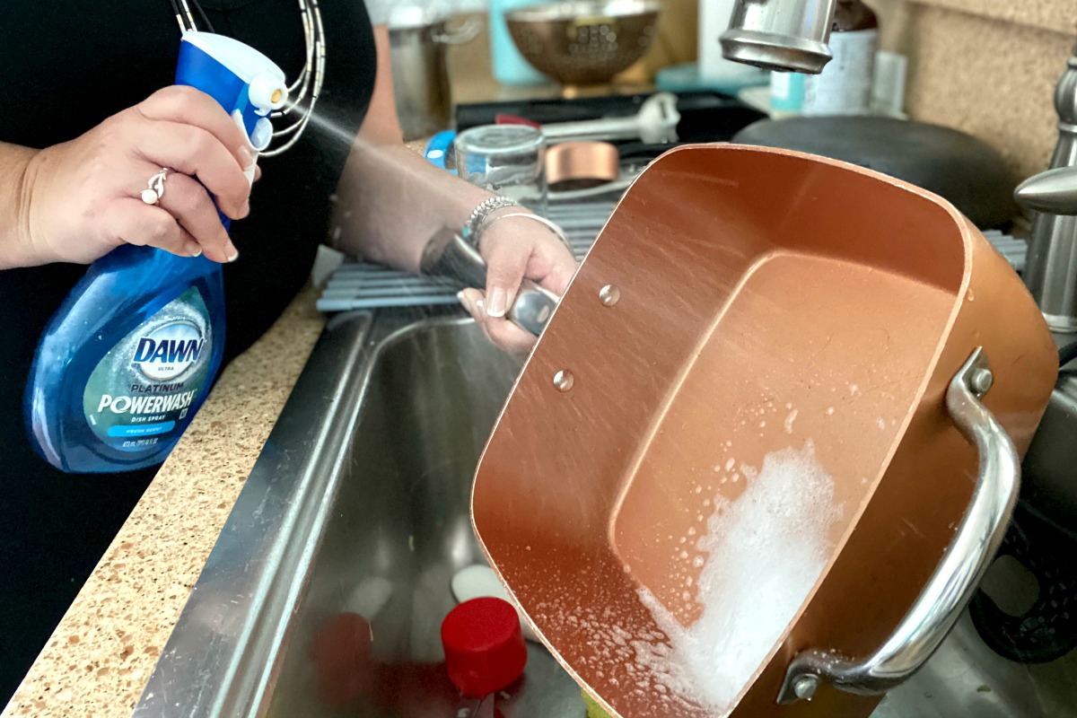 spraying dawn powerwash onto dishes