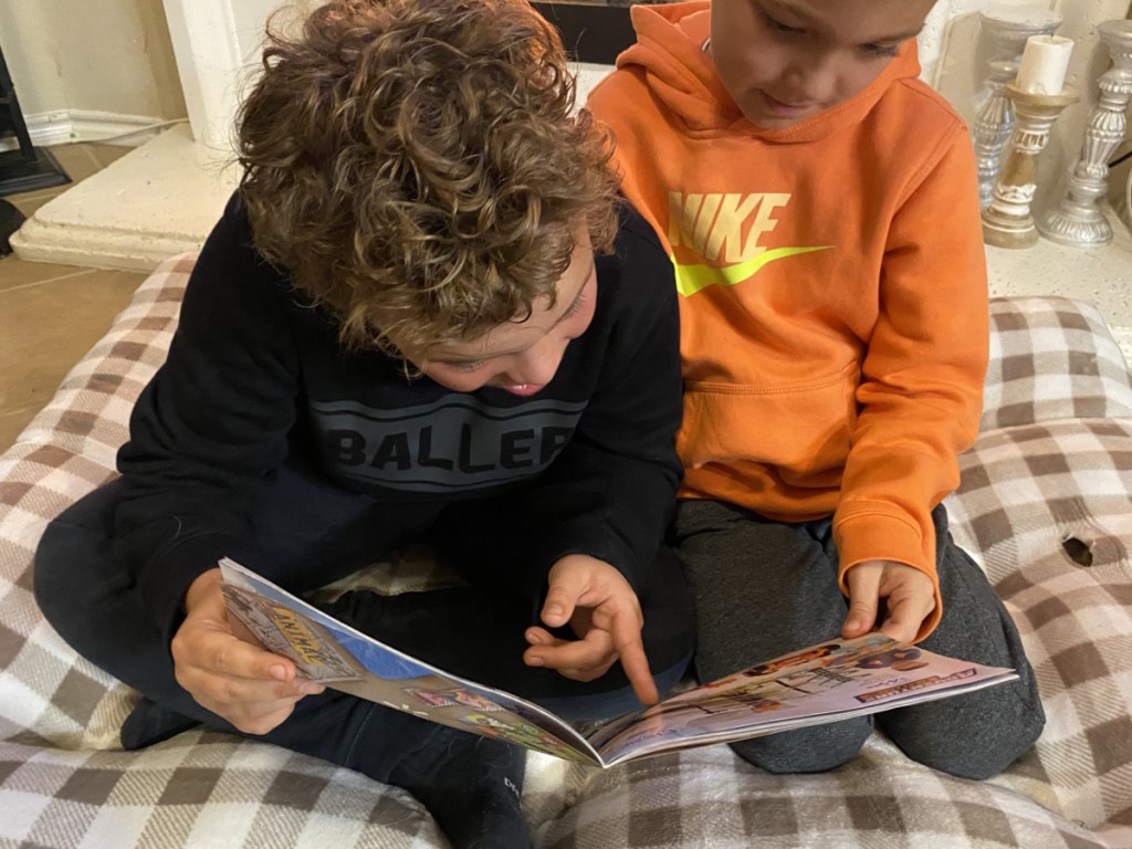 two boys holding the walmart 202 toy catalog