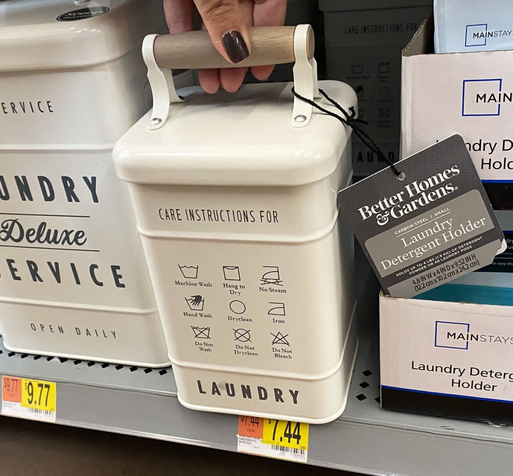 woman holding lid of a small metal laundry container on a walmart shelf