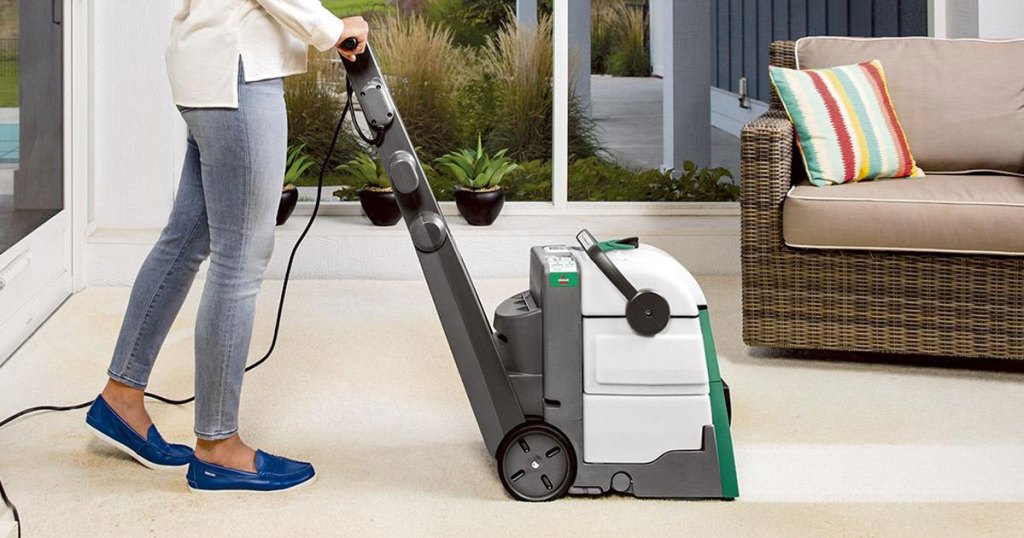 woman using a bissell professional carpet cleaner to clean carpeting