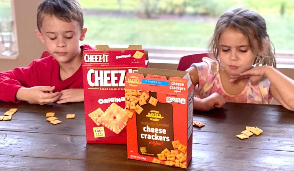 Two kids at a table with boxes of crackers