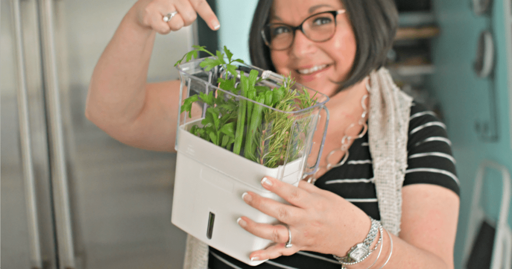 woman holding fresh herb keeper 