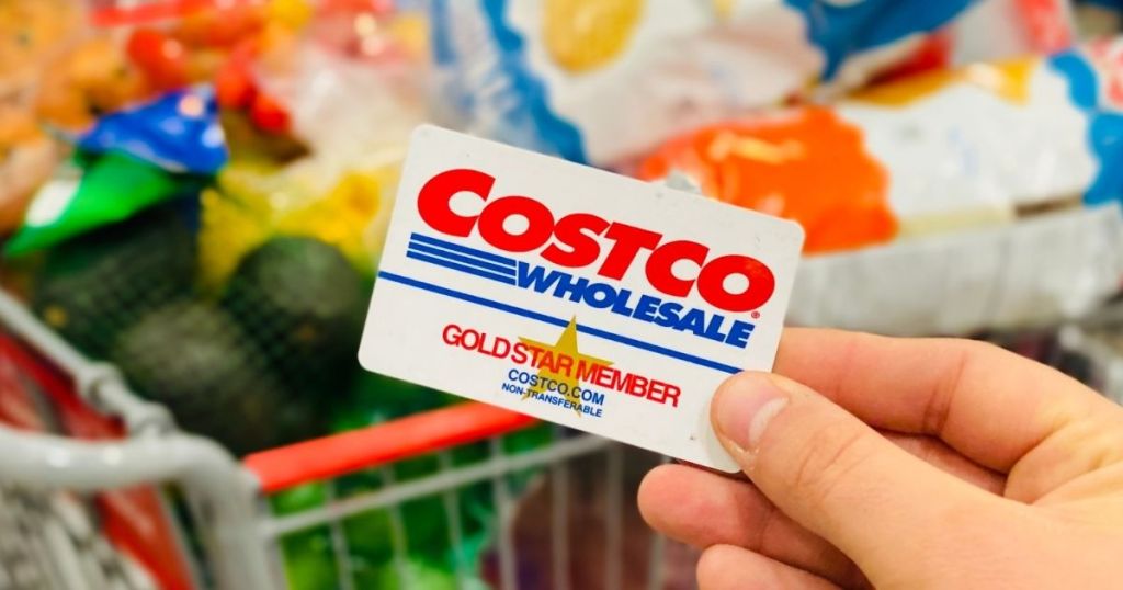 hand holding a Costco membership card in front of groceries