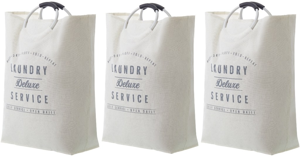 Three creamy white laundry totes that are farmhouse style with round metal handles