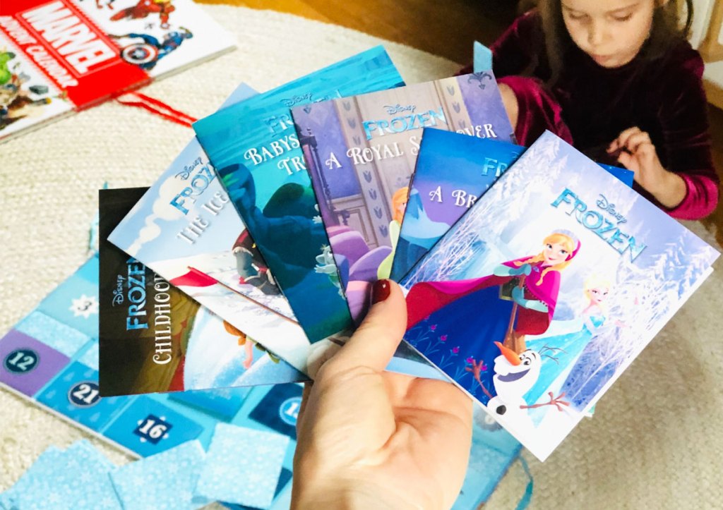 person holding up a variety of books that onlinee inside the disney frozen storybook advent calendar