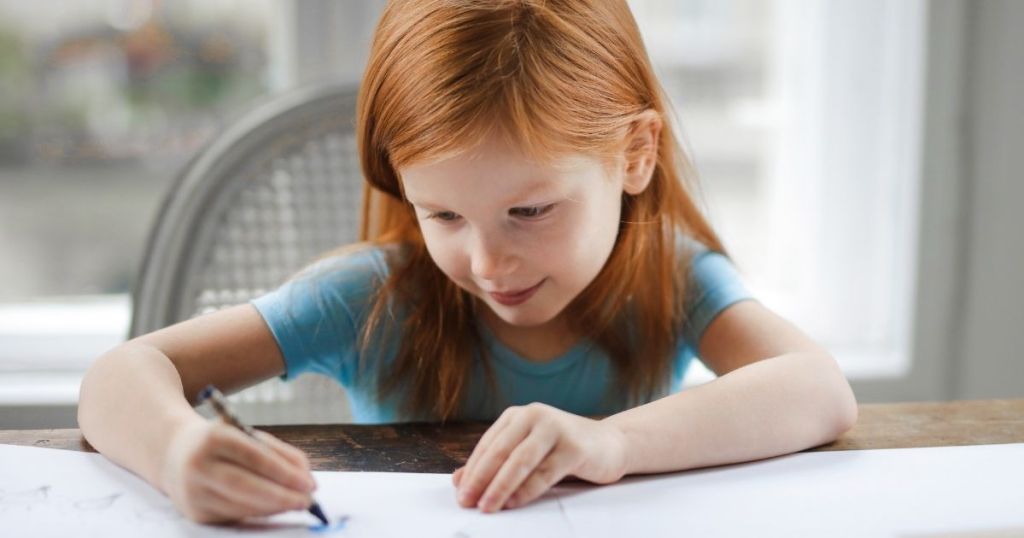 girl coloring on a worksheet