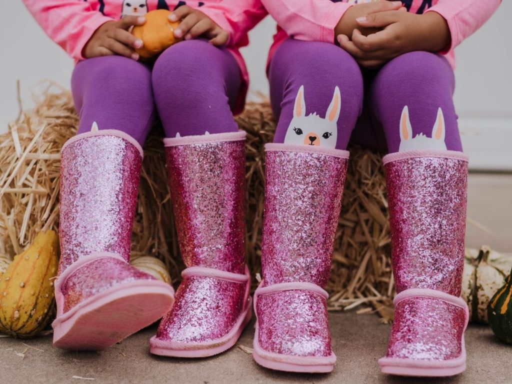 girls sitting on hay bale wearing pink sparkle boots