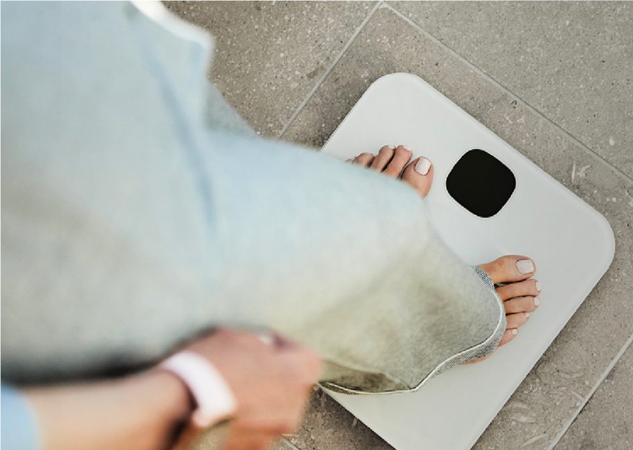 person stepping on white scale