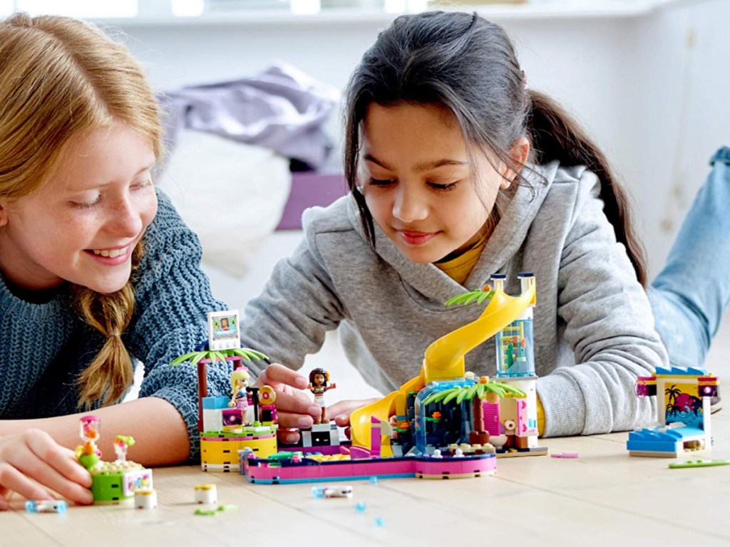 two girls playing with building toy set on floor