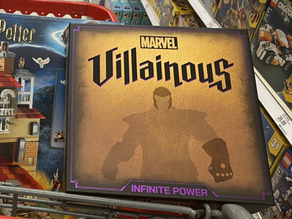 Marvel themed board game in a red shopping cart near other toys