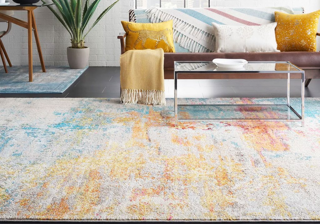 multi-colored absract area rug in front of couch