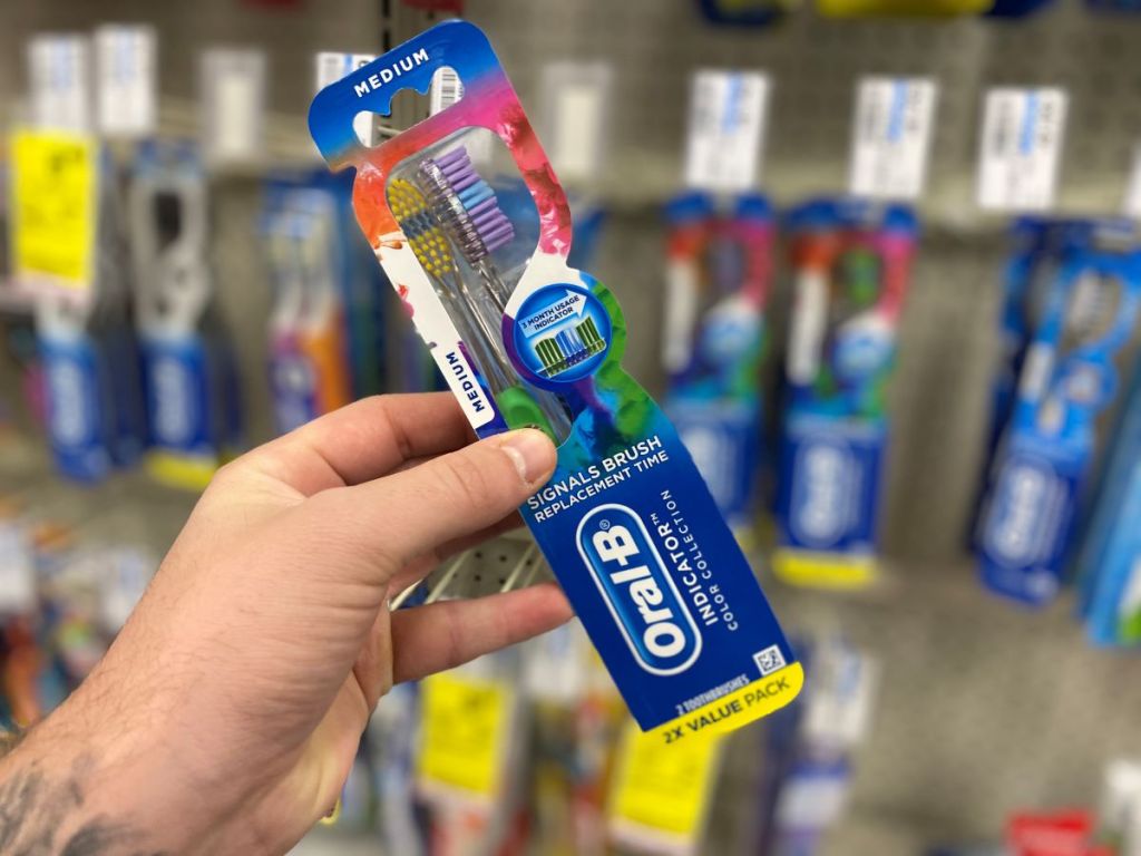 hand holding a 2-pack of Oral-B Toothbrushes