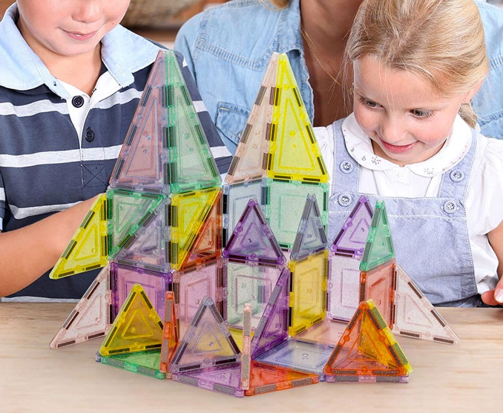 girl and boy playing with a glittery magnetic building block set