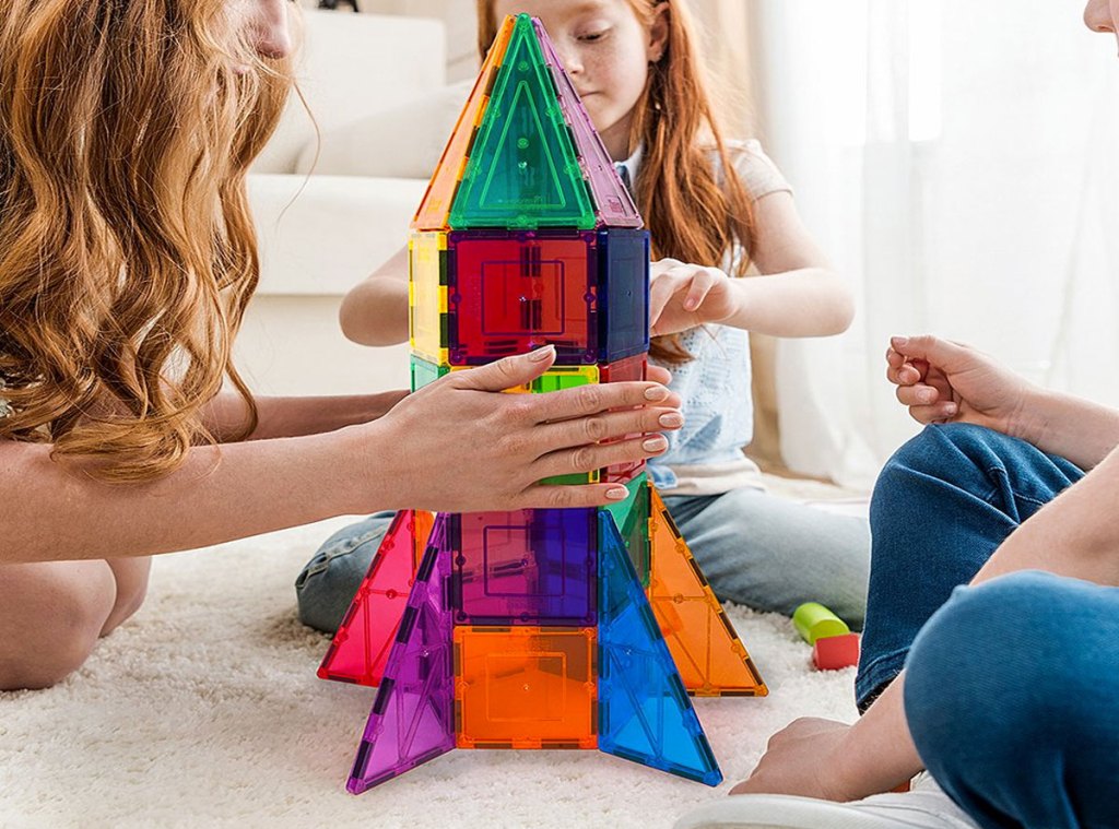 kids playing with magnetic building block set in the shape of a rocket